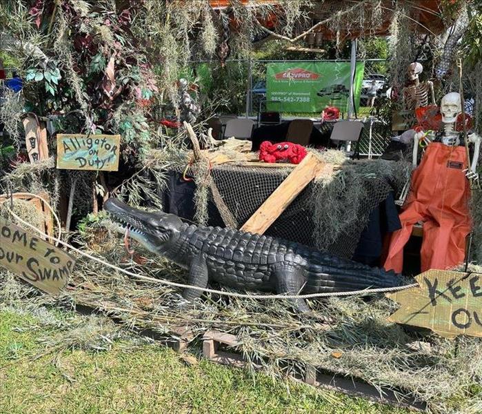 booth decorated as a swamp, Giant alligator, skeleton of a man fishing  